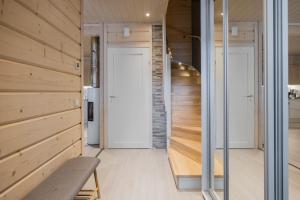a room with wooden walls and a door and a bench at Elves Eco Design House A in Rovaniemi