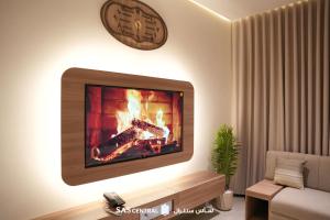 a living room with a fireplace and a clock on the wall at SAS Central in Salalah