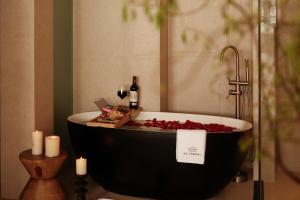 una bañera con velas y botellas de vino y dos velas en Da Li Yuan Lu Hotel, en Antigua Ciudad de Dali