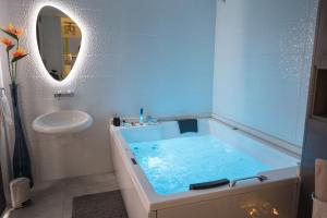 a bathroom with a blue tub and a sink at Apartment PLAZA -Wallbox 11kW- Private SPA- Jacuzzi, Infrared Sauna, Luxury massage chair, Parking, Entry with PIN 0 - 24h, FREE CANCELLATION 24 hours before Check In,Premium pillows and mattress in Slavonski Brod +56 photos