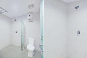 ein weißes Badezimmer mit Toilette und Dusche in der Unterkunft Collection O Bali Sanur near Bali Mandara Hospital in Sanur + 18 Fotos