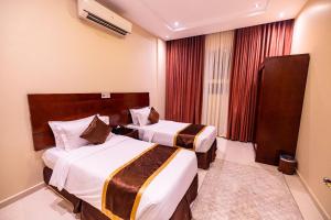 جبلة للشقق المخدومة Jabah Serviced Apartments في حائل: غرفة فندقية بسريرين ونافذة