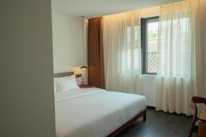 蘇州市にあるXingLe All-inclusive Suzhou Courtyard Houseの白いベッドと窓のある寝室