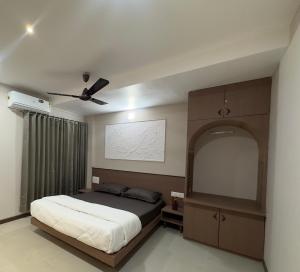 a bedroom with a bed and a ceiling fan at Krushnkunj Executive in Kolhapur