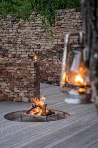 a fire pit on a deck next to a stone wall at The Outpost in Makuleke Contract Park