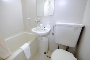 Un baño blanco con inodoro y lavabo. en Fushimi Railway House, en Kioto 53 fotos más