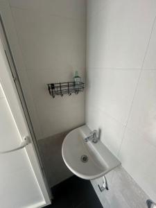 オーロヴィルにあるAuroville Room Guest House Humblepieの洗面台と棚のある白いバスルーム