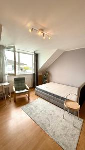 a bedroom with a bed and a chair at Apartment am Hafen in Düsseldorf