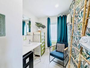 a bathroom with a sink and a blue chair at Suite Maëlle - Évasion & Confort in Bray-Dunes +27 photos