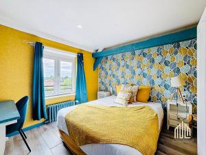 a bedroom with a bed and a yellow wall at Suite Maëlle - Évasion & Confort in Bray-Dunes