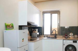 a kitchen with a white refrigerator and a window at La Maison d'Emma Centre-ville in Pointe-Noire