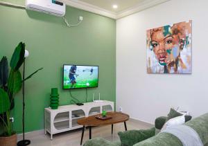a living room with a couch and a flat screen tv at La Maison d'Emma Centre-ville in Pointe-Noire