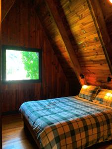 a bed in a wooden room with a window at Chalet AbA, proche Luchon in Cierp