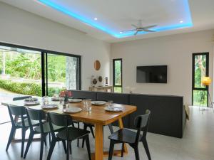 una sala da pranzo con tavolo e sedie di Tropical 4br Jungle View Villa Near Lamai Beach a Lamai Beach