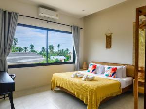 una camera da letto con un letto e una grande finestra di Tropical 4br Jungle View Villa Near Lamai Beach a Lamai Beach Altre 25 foto