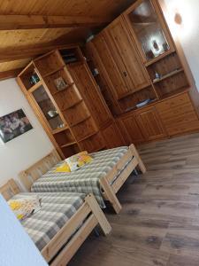 a bedroom with two beds in a room with wooden walls at Cá del Manöl in Villa di Tirano