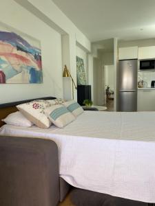a large white bed in a room with a refrigerator at Penthouse Asuncion Feria in Seville
