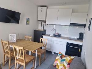 eine Küche mit einem Holztisch und Stühlen in einem Zimmer in der Unterkunft Appartement F2 5B in Martres-de-Veyre