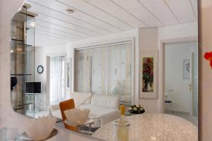 a white living room with a table and chairs at Ferienwohnung am Schlosssee in Salem