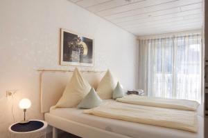 a white bedroom with a bed with a window at Ferienwohnung am Schlosssee in Salem
