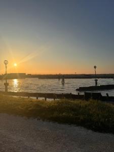 a sunset over a body of water with people in it at Sweet charm in Venice in Tessera