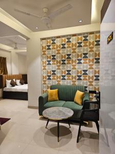 a living room with a green couch and a table at Lotus Excutive in Pune
