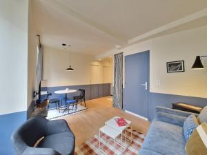 a living room with a blue couch and a table at Puy-de-Dôme #Hypercentre in Clermont-Ferrand
