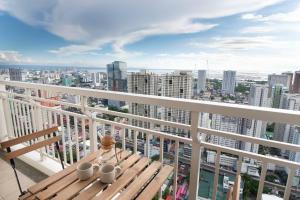 a balcony with a wooden bench and a view of a city at Aston Residences in Manila