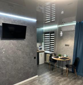 ApartCenter Студия VIP в центре города Гагарина في كريفوي روغ: مطبخ مع طاولة وتلفزيون على الحائط