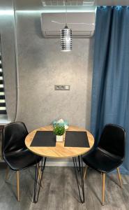 ApartCenter Студия VIP в центре города Гагарина في كريفوي روغ: طاولة وكراسي في غرفة مع ستارة زرقاء