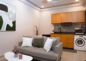 a living room with a couch and a kitchen at La maison D'Emma Centre-ville in Pointe-Noire