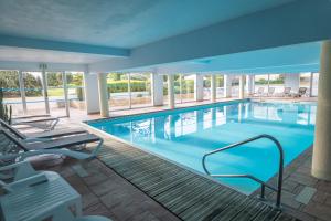 a large pool with blue water in a building at Hotel Europa in Quiberon