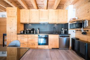 a kitchen with wooden cabinets and a stove at Lune des Alpes - Chalet de charme in Valloire +25 photos