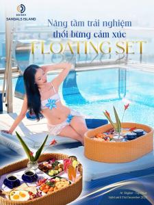 a woman in a bikini sitting next to a swimming pool at SANDALS ISLAND HOTEL in Nha Trang