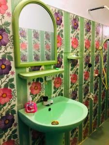 een badkamer met een groene wastafel en een spiegel bij Saman Restaurant - Family House in Arugam Bay
