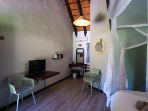 a bedroom with a bed and two chairs and a desk at Okahandja Country Hotel in Okahandja