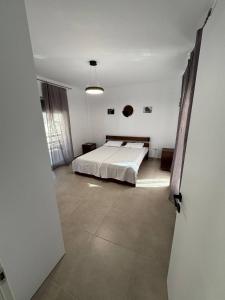 a bedroom with a bed in a white room at Panorama Apartment in Kavála