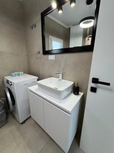 a bathroom with a sink and a washing machine at Panorama Apartment in Kavála +17 photos