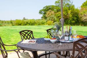 a table with wine glasses and fruit on it at Marrington Farmhouse in Chirbury
