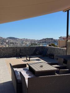 a patio with a table and chairs on a roof at Panorama Apartment in Kavála