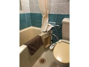 a bathroom with a toilet and a tub with a shower curtain at Business Hotel Crescent - Vacation STAY 49938v in Tokyo