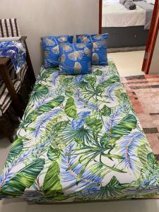 a bed with a colorful comforter on it at Royal Oceancrest Mactan - Relaxing Sunset View in Lapu Lapu City +36 photos