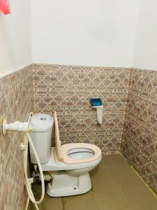 een badkamer met een toilet in een bakstenen muur bij Saman Restaurant - Family House in Arugam Bay +21 foto's
