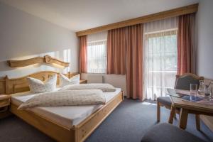 una habitación de hotel con dos camas y una mesa en Mehlerhof, en Tux