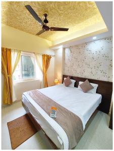 a bedroom with a large bed with a ceiling fan at Hotel New J-Aradhya ! Near Sea Beach And Shree Jagannath Temple - Free Wifi and Parking Facilities - Fully-Air-Conditioned Rooms - Top Rated Hotel In Puri in Puri