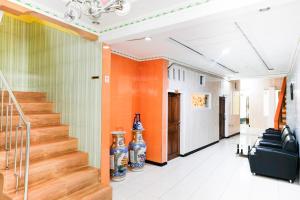 a hallway with stairs and vases in a building at Urbanview Hotel Mawar Sharon near Alun Alun Batu in Batu