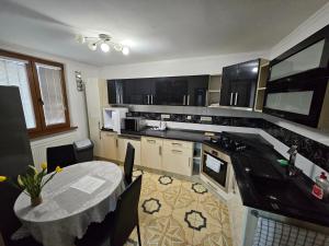 a kitchen with a table and a counter top at APARTMAN WOLF Luxusné priestranné ubytovanie s Výhľadom na hory s Bezplatným Parkovaním Veľkou SMART TV Rýchlym Optickým Internetom Priamo v PB Tichá lokalita Všetko na blízku Vhodné pre Rodinu Skupinu Pracovné cesty aj Turistiku Plne vybavená Kuchyňa in Považská Bystrica