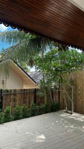 ein Haus mit einem Holzzaun und einer Palme in der Unterkunft Island Serenity Villa in Hinkong