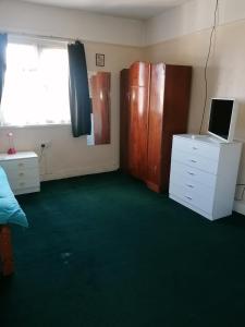 una habitación con una cama y un escritorio con una computadora en Central location, en Staines upon Thames