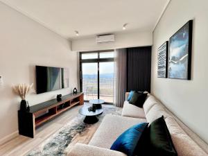a living room with a couch and a tv at The Trilogy Collection Luxury One Bedroom in Pretoria